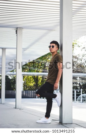 Young mexican hipster fashion with serious poses and black glasses in a minimalist environment