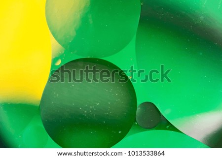 mixing water and oil, beautiful color abstract background based on green and yellow circles and ovals, macro abstraction