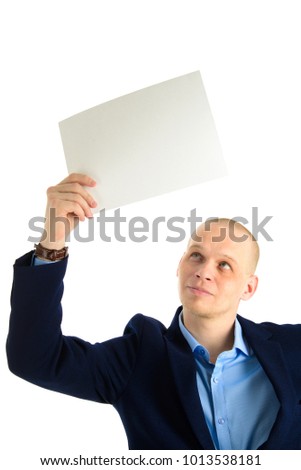 Handsome businessman in stylish suit holding empty sheet of paper over his head isolated on white background