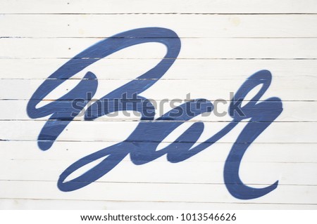 The inscription "Bar" on the fence. Blue inscription in a beautiful font. The atmosphere of summer, relaxation, rest. Place for parties and alcohol.
