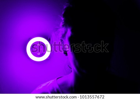 Lamp night light in a dark background. Vintage effect style picture. ring lamp. Neon light circle. the light takes the shape of a circle.the woman hiding in the dark. a symbol of violence for women