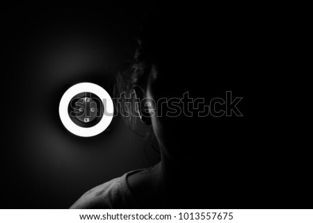 Lamp night light in a dark background. Vintage effect style picture. ring lamp. Neon light circle. the light takes the shape of a circle.the woman hiding in the dark. a symbol of violence for women