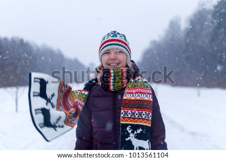 Portrait of girl in knitted hat in winter forest on blurred background