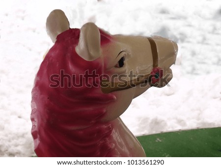 head of a toy horse against the background of snow