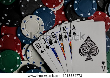The player holds five playing cards in his hand. Royal Flash, card deck, poker royal flash on cards and poker chips on green casino table / on a black background. success in gambling. soft focus