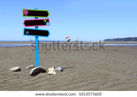 Blank directional signage on a beautiful beach, add your own text. 