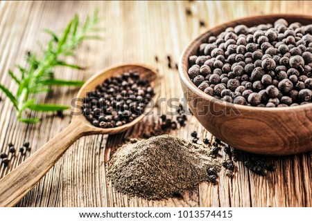 Black pepper in bow on wooden table. Pile of ground black pepper. Royalty-Free Stock Photo #1013574415