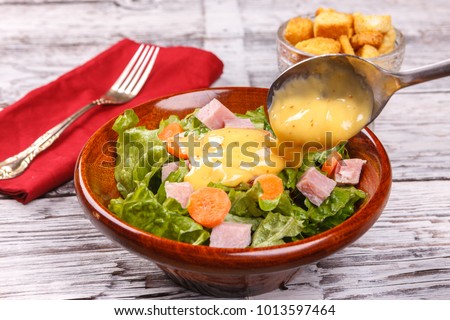 Pouring dressing on a salad. Royalty-Free Stock Photo #1013597464