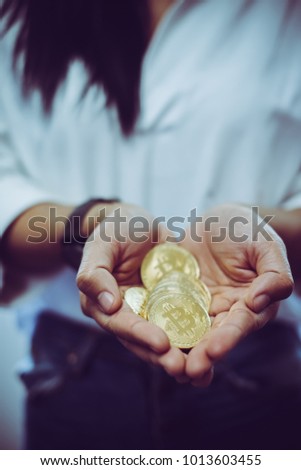 Cryptocurrency golden bitcoin coin. Woman holding in hand symbol of crypto currency - electronic virtual money for web banking and international network payment, selective focus, toned