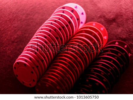 Poker game concept. Casino Concept for business risk chance good luck or gambling. Stack of Poker chips / poker chips stack in red light on gaming poker table. closeup photo. soft focus