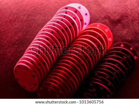 Poker game concept. Casino concept for business risk, luck chance or gambling. Stack of poker chips, stack of poker chips in red light on the game poker table. close-up photo. soft focus