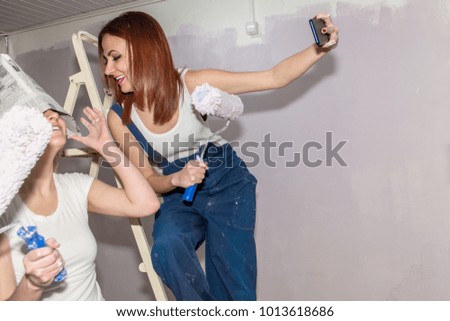Two Smiling Attractive Young Women take selfie and having fun  - Spring Cleaning and Wall Painting Concept