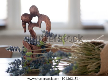 A figurine in the form of two men kissing a man and a woman against a background of flowers. A symbol of love. The concept of Valentines Day.
