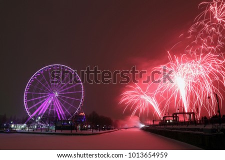 Great wheel of Montreal. Panoramic colorful silhouette by night. Colorful fireworks explode near the observation wheel at night. luminous colorful ferris wheel in the Old Port.