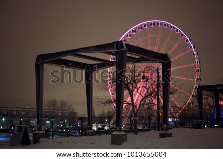 Great wheel of Montreal. Panoramic colorful silhouette by night. Colorful fireworks explode near the observation wheel at night. luminous colorful ferris wheel in the Old Port.