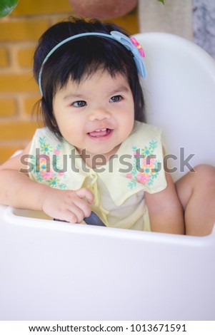 portrait of asian little girl smiling with all her teeth. Happy kid in sunny afternoon makes every parent feel good. Childish smile is a source of positive emotions.