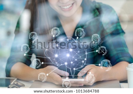 Polygonal brain shape of an artificial intelligence with various icon of smart city Internet of Things Technology over Asian businesswoman hand using the smart mobile phone,AI and business IOT concept Royalty-Free Stock Photo #1013684788