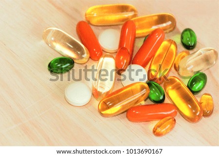 Taking vitamins and supplements for a healthy life. Multivitamins on wooden background. 