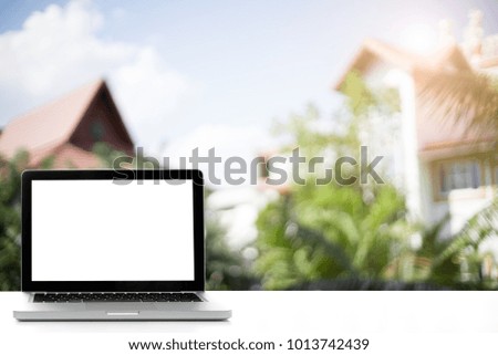 Laptop with blank screen on Empty space desk white at home Interior blurred background.
