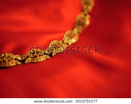 Gold jewelry on red satin back drop valentines day gift.