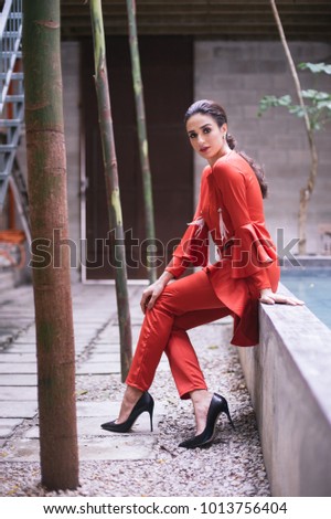 Portraiture Beautiful Young female business woman wearing red fancy dress outdoor.Professional female caucasian model with red office attire.