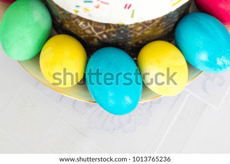 Easter cake with glace icing and easter eggs on white table cloth background.