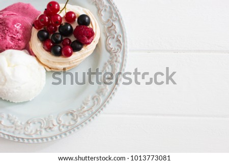 Three dessert ice cream berry pavlova nests kitchen wooden table selective focus.