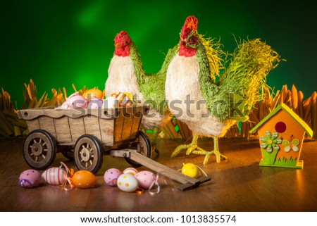 Chicken and rooster with Easter eggs. The Feast of Easter. Decorated Easter eggs.