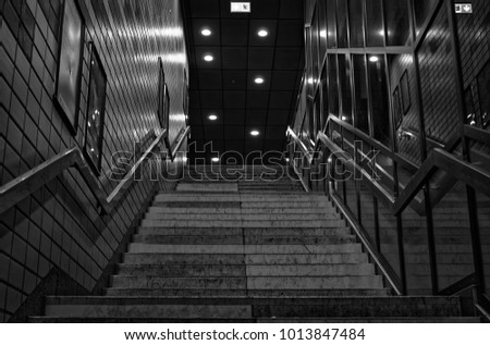 Stairs of the subway station Jungfernstieg in Hamburg in Germany Europe in black and white optics with emergency exit sign
