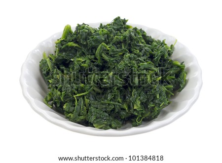 A single serving of cooked chopped spinach in an old bowl on a white background. Royalty-Free Stock Photo #101384818