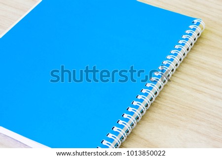 Blank blue book empty cover book spiral stationery school supplies for education business idea book cover design note pad memo on wooden background.