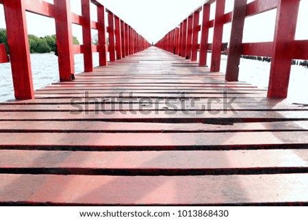 Red wooden bridge on sunshine day.