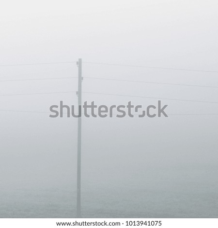 Lonely electricity cable line in strong fog