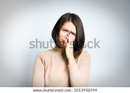 tender young woman sad, crying, in a pink sweater, isolated on background, studio photo