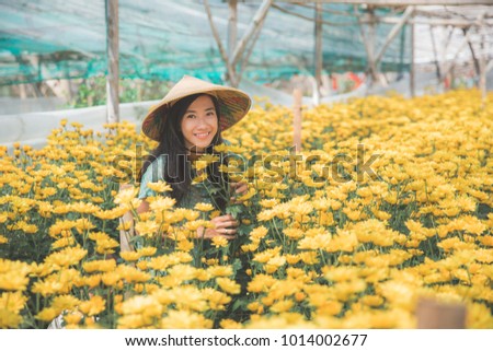 portrait of happy young asian woman in chamomile farm