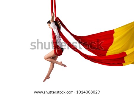 Beautiful aerialist girl doing acrobatic and flexible tricks on red aerial silks (tissues) isolated on white background
