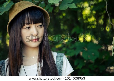 Beautiful Asian women in front of the green leaves