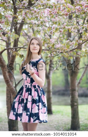 Slavic girl in spring in park. sakura blossom background