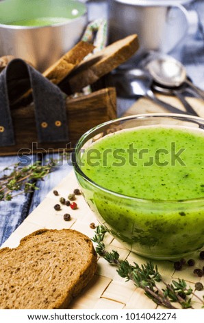 Green cream soup in a bowl on the table. Selective focus.