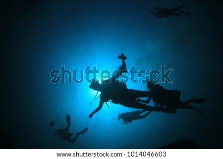 Scuba divers silhouette in ocean