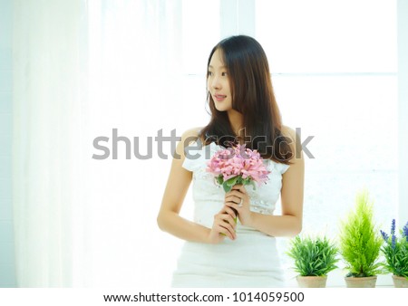 Korean woman in wedding dress holding flower bouquet