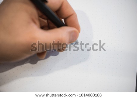 left hand writing on a paper with a pen