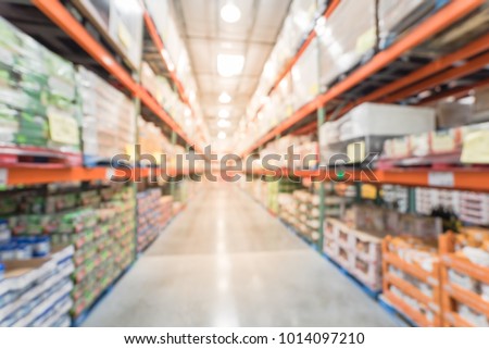 Blurred wholesale store aisle with big boxes of product from floor to ceiling racks. Large warehouse wholesale in America. Defocused industrial distribution storehouse abstract background Royalty-Free Stock Photo #1014097210