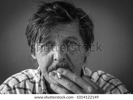 old man smoking black and white portrait on grey background
