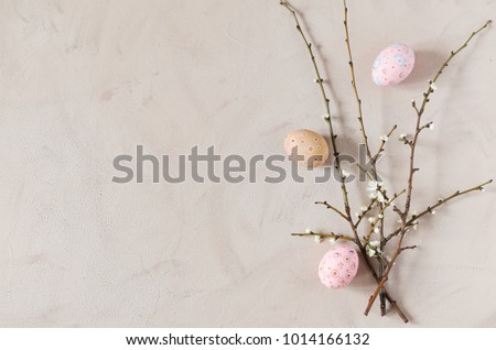 Easter background in beige color with spring flowering branches and easter eggs. Top view, copy space. Royalty-Free Stock Photo #1014166132
