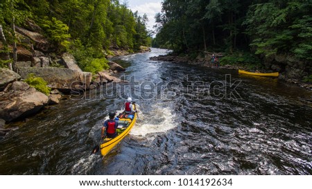 A group of people paddling the whitewater of the Noire River in Quebec, Canada.