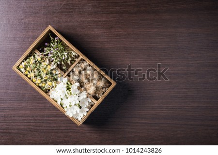 Flowers in box on wood background.