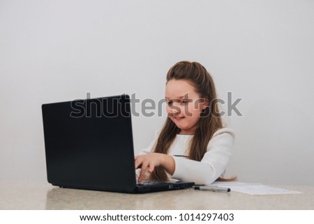 Nice smiling girl searching something in Internet with curiosity.