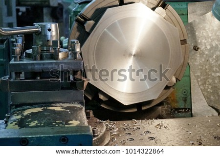 Mechanic Engineer Turner Miller verifies the accuracy of manufacturing steel parts with a scale the size of the measurement device. In the dark room with lamp background.
