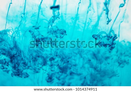 Blue ink is dissolving in the water